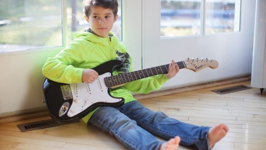 Young child holding guitar – 2178-min Young child holding guitar - 2178-min